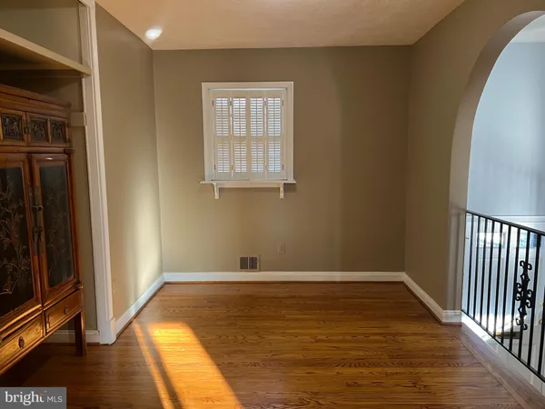 a view of an empty room with wooden floor and closet