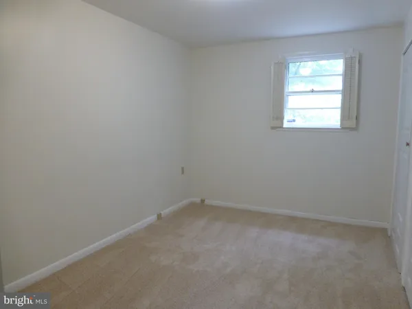 an empty room with fan and windows
