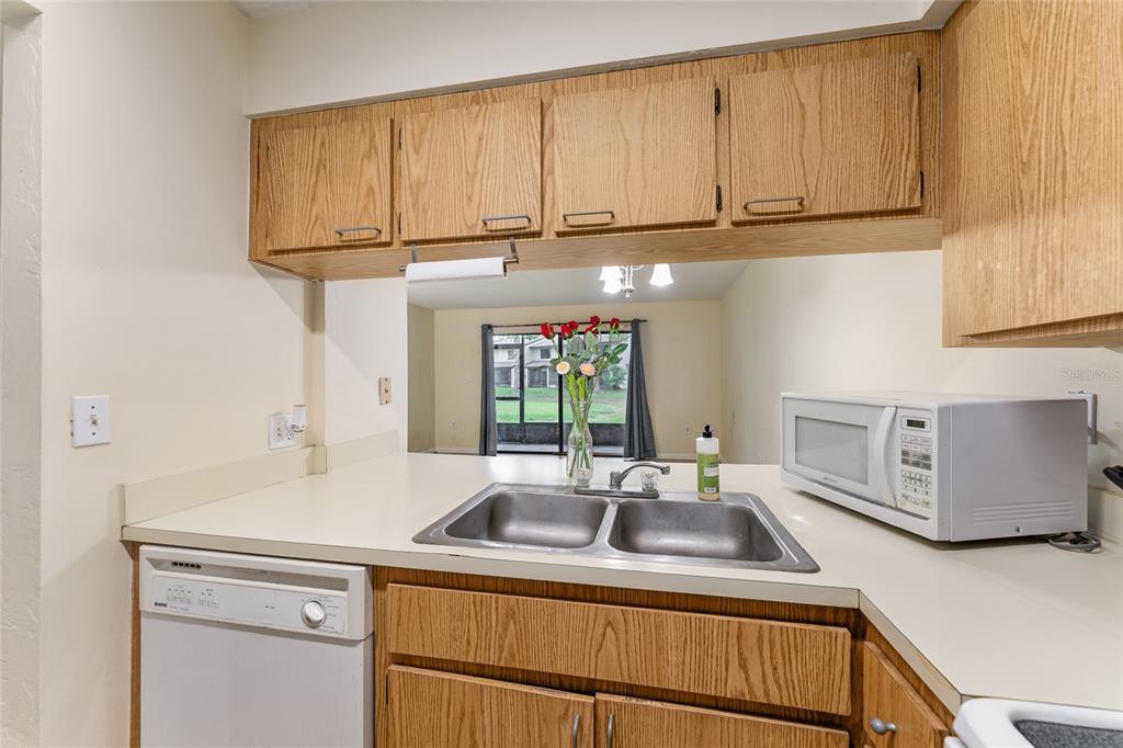 2635 Southwest 35th Place, Unit 604 Gainesville, FL 32608 - Photo 6 of 28 a kitchen with stainless steel appliances granite countertop a sink a stove and a microwave