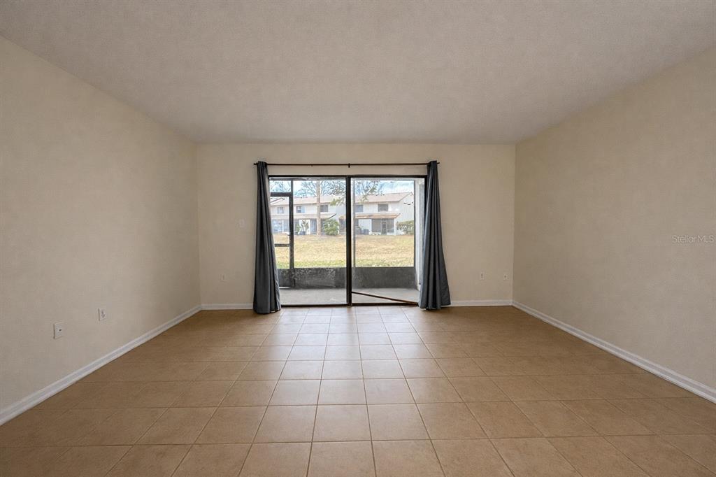 2635 Southwest 35th Place, Unit 604 Gainesville, FL 32608 - Photo 7 of 28 an empty room with sliding glass door