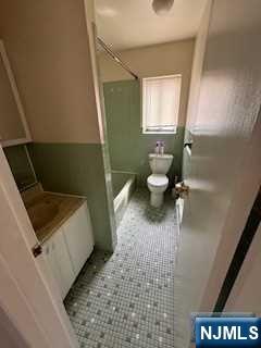 340 Hudson Street, Unit 26 Hackensack, NJ 07601 - Photo 6 of 7 a bathroom with a sink a toilet and a mirror
