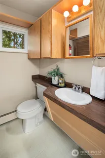 a bathroom with a granite countertop toilet and a sink