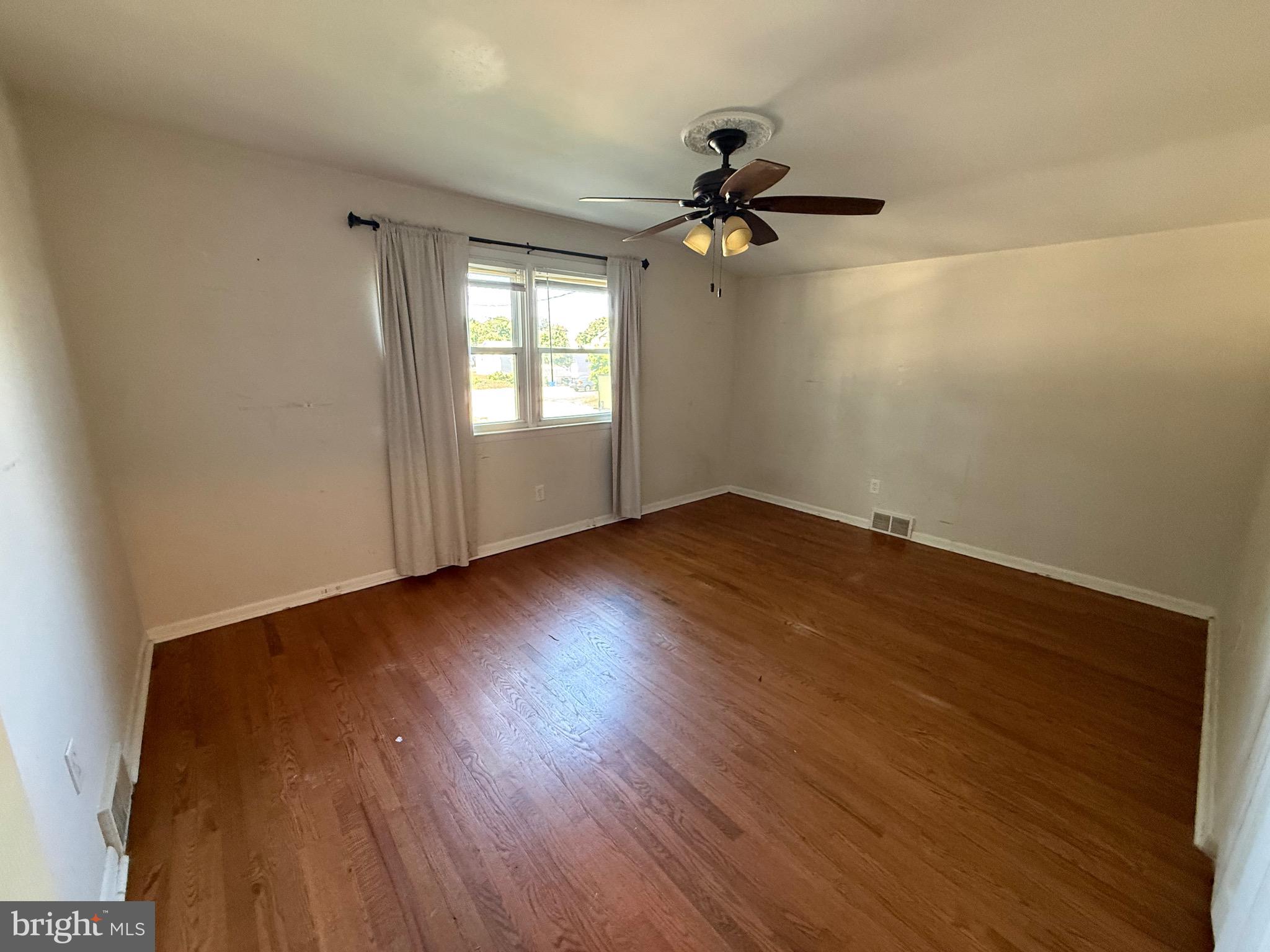 174 Kansas Road Pennsville, NJ 08070 - Photo 18 of 22 a view of empty room with wooden floor and fan