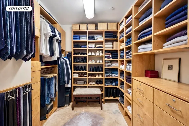 a view of walk in closet with clothes and shoes