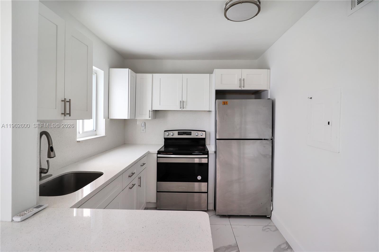 3601 Southwest 2nd Street, Unit 3601 Miami, FL 33135 - Photo 4 of 19 a kitchen with a refrigerator sink and cabinets