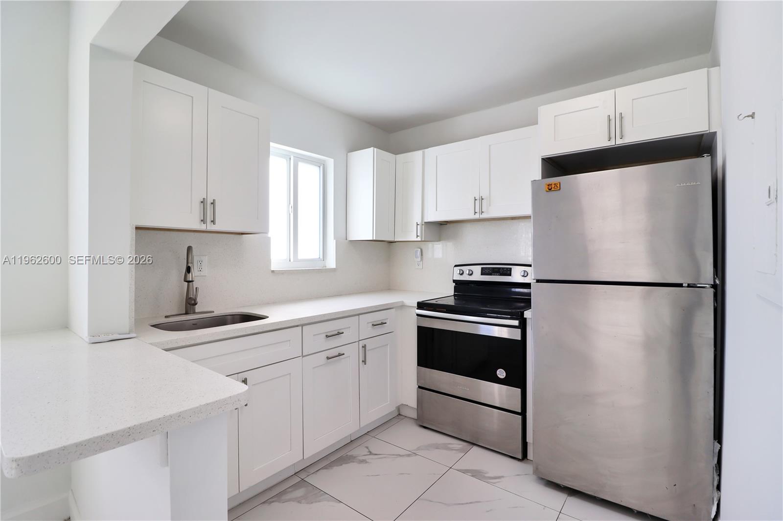 3601 Southwest 2nd Street, Unit 3601 Miami, FL 33135 - Photo 5 of 19 a kitchen with white cabinets and stainless steel appliances
