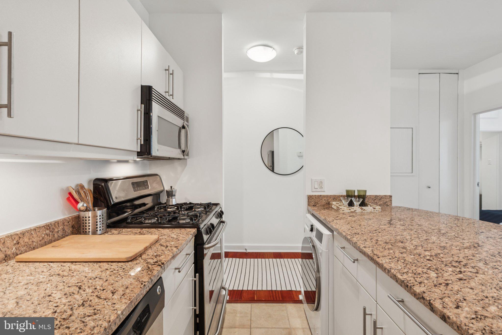 219 South 18th Street, Unit 1605 Philadelphia, PA 19103 - Photo 4 of 15 a kitchen with granite countertop a sink a stove and cabinets