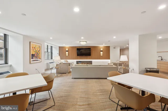 a large living room with stainless steel appliances furniture a dining table and chairs