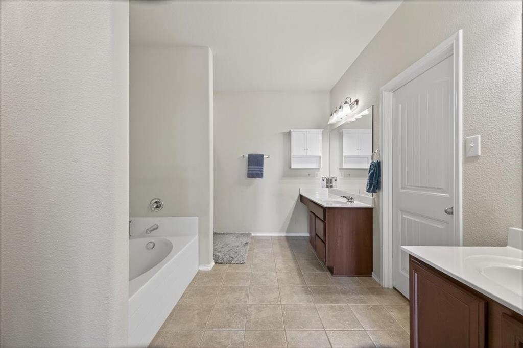 9332 San Tejas Drive Fort Worth, TX 76177 - Photo 15 of 38 a spacious bathroom with a bathtub sink and mirror