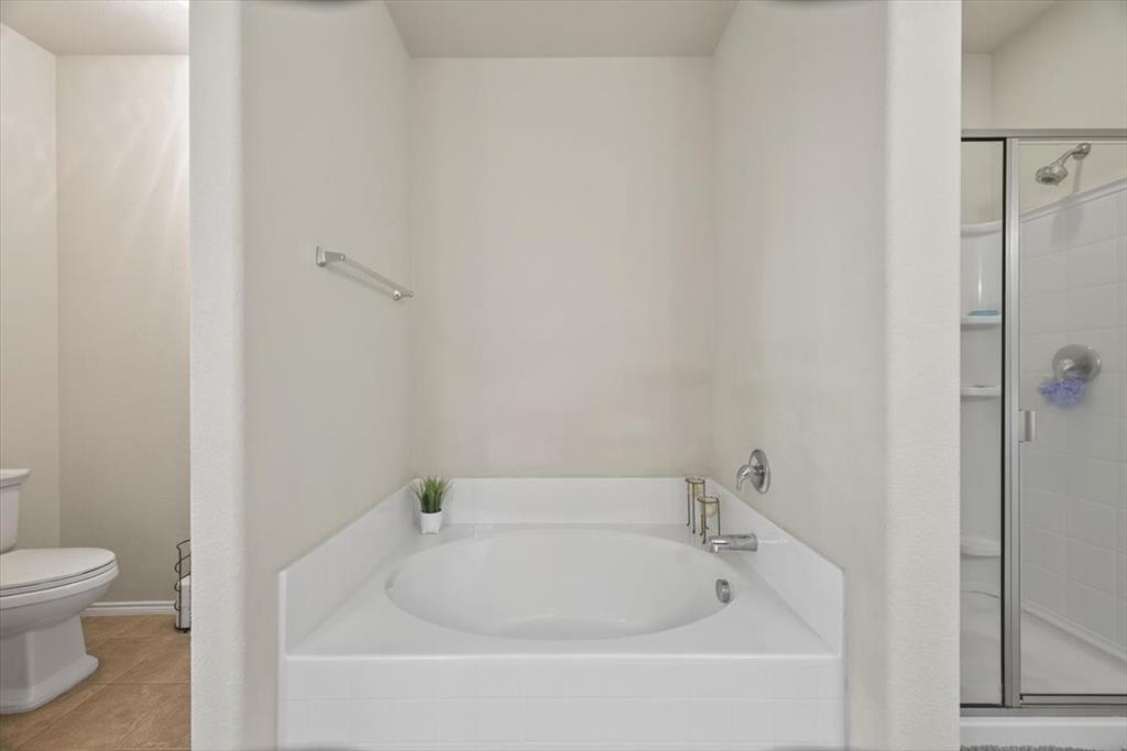 9332 San Tejas Drive Fort Worth, TX 76177 - Photo 17 of 38 a white bath tub sitting next to a white toilet