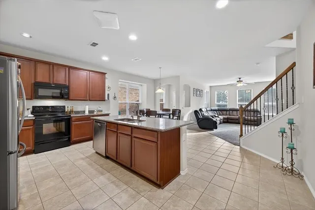 a kitchen with stainless steel appliances granite countertop a sink and a refrigerator