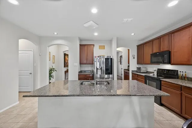 a kitchen with stainless steel appliances granite countertop a refrigerator and a sink