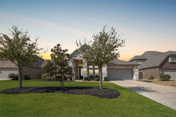 a view of a house with a big yard and large trees