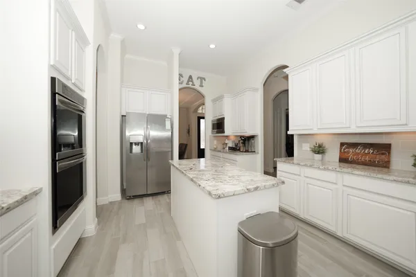 a kitchen with stainless steel appliances granite countertop a sink a stove and a refrigerator