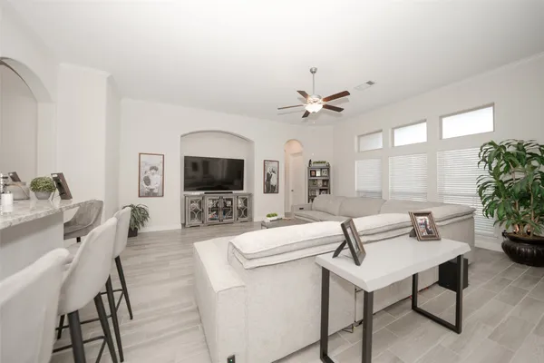 a living room with furniture a flat screen tv and a large window