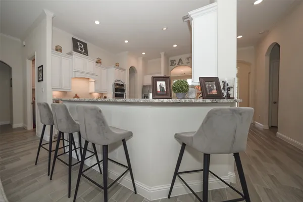 a dining room with stainless steel appliances kitchen island granite countertop a dining table chairs and a refrigerator