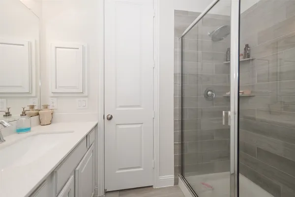 a bathroom with a shower sink and vanity