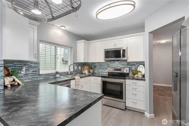 a kitchen with stainless steel appliances granite countertop a stove sink and cabinets