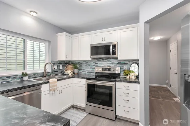 a kitchen with a sink stove top oven and microwave