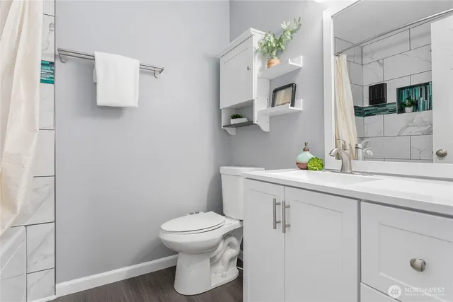 a bathroom with a toilet sink and mirror