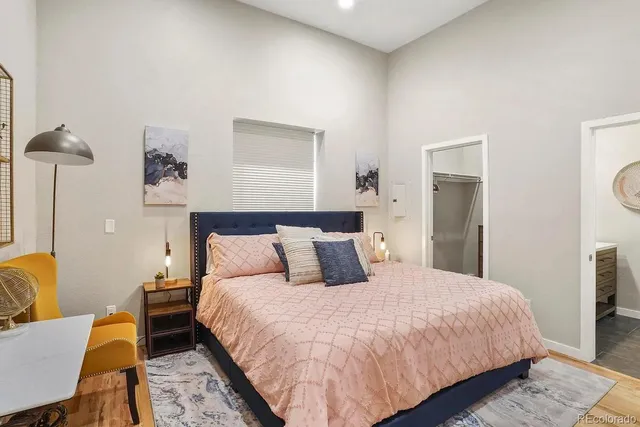 a bedroom with a bed a lamp and a dresser