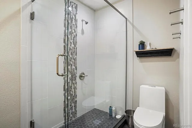 a bathroom with a shower a toilet and a sink