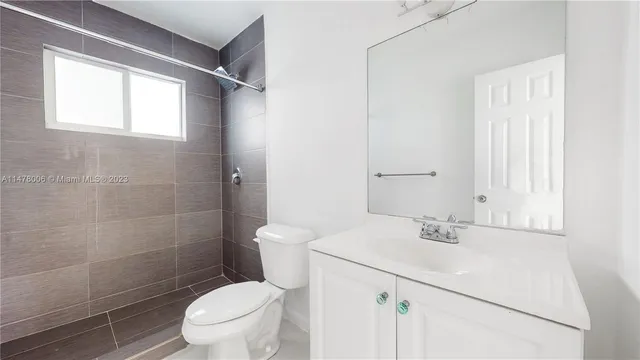 a white toilet sitting next to a bathroom sink