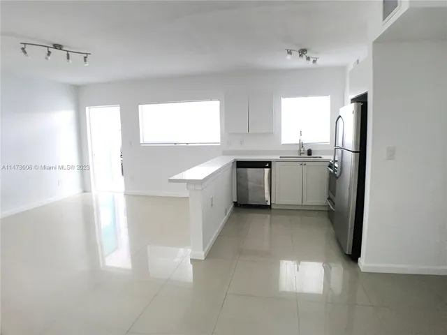 a kitchen with lots of counter top space and painting on the wall