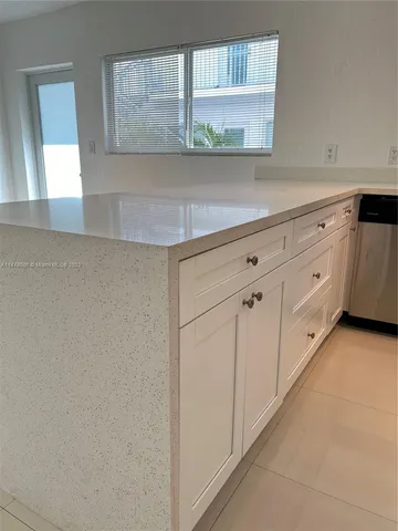 a bathroom with a sink a toilet a window and a mirror