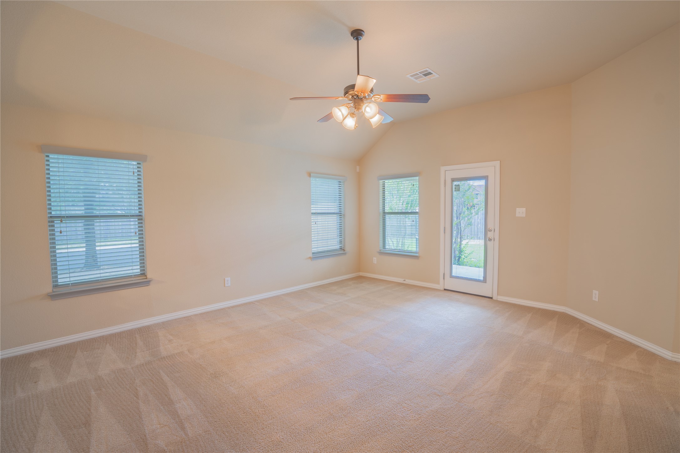 403 Tascate Street Georgetown, TX 78628 - Photo 7 of 26 A spacious room offers comfortable carpeted flooring, ample natural light, and convenient outdoor access.