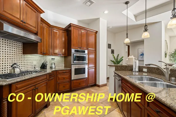 a kitchen with stainless steel appliances granite countertop a sink a stove and a refrigerator