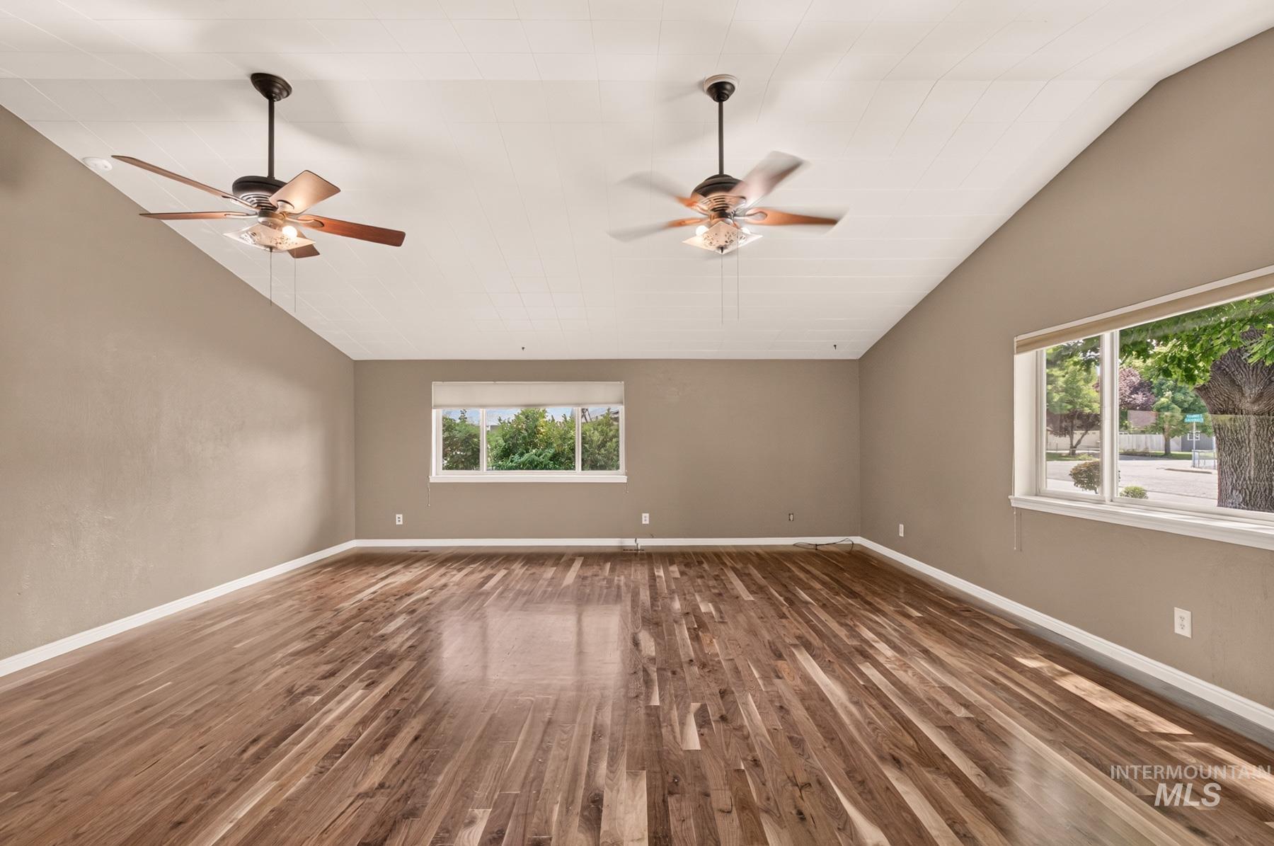 9622 Delaware Street Boise, ID 83709 - Photo 21 of 48 Expansive room featuring rich wood-finish flooring, vaulted ceilings, and two ceiling fans with integrated lighting