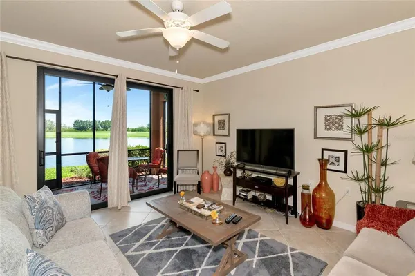 a kitchen with stainless steel appliances a sink a stove a refrigerator cabinets and chairs
