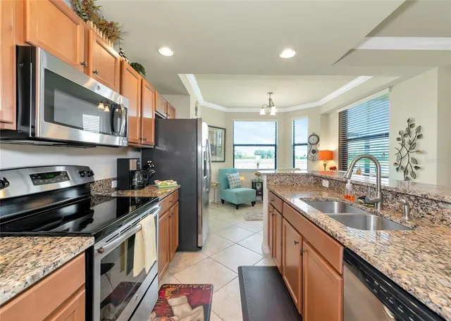 a kitchen with stainless steel appliances granite countertop a sink stove and refrigerator