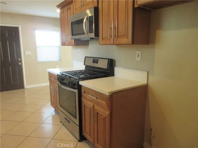 a kitchen with stainless steel appliances granite countertop a stove a microwave and a sink