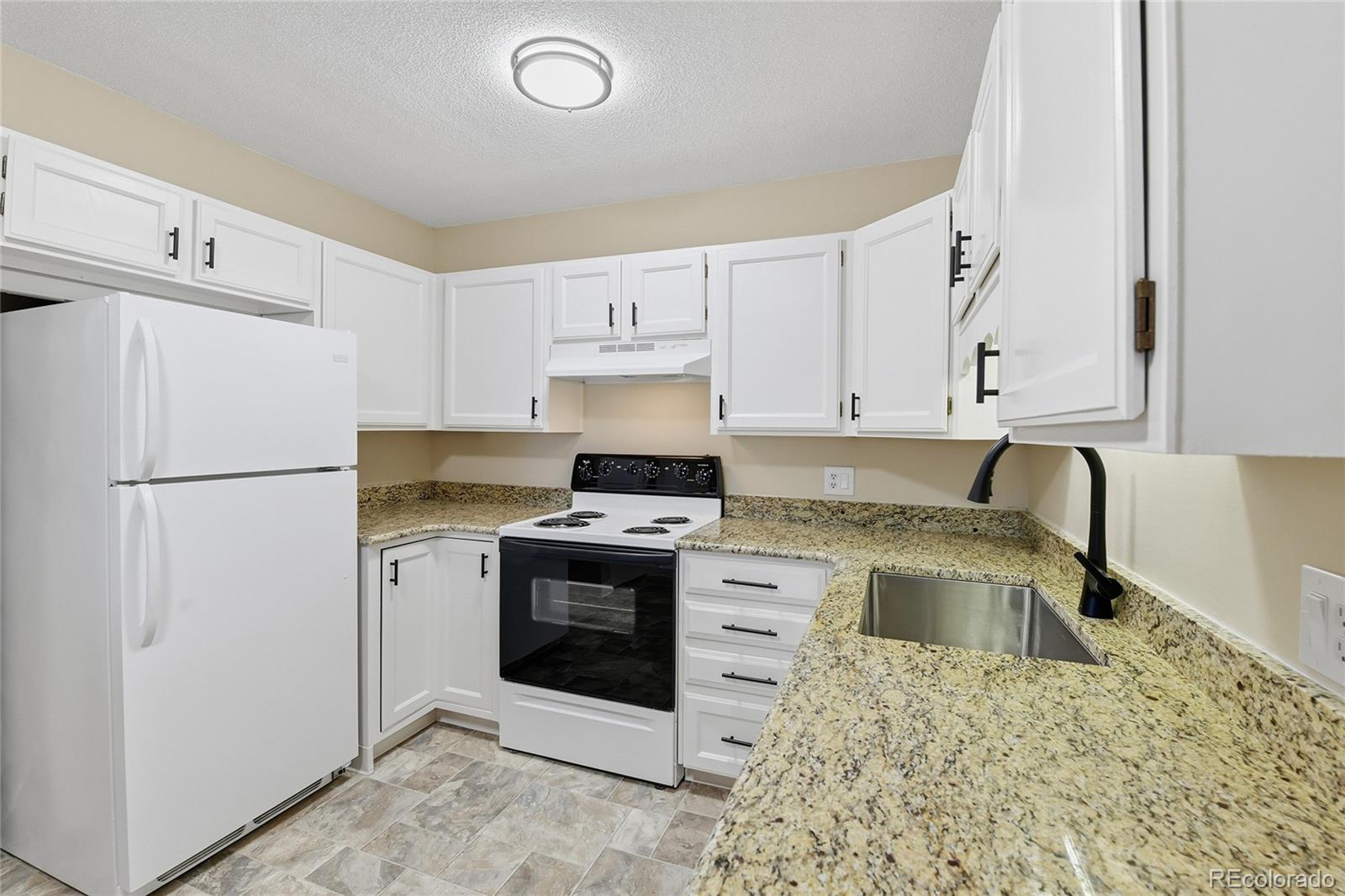 3022 South Wheeling Way, Unit 309 Aurora, CO 80014 - Photo 11 of 26 a kitchen with a stove sink and refrigerator