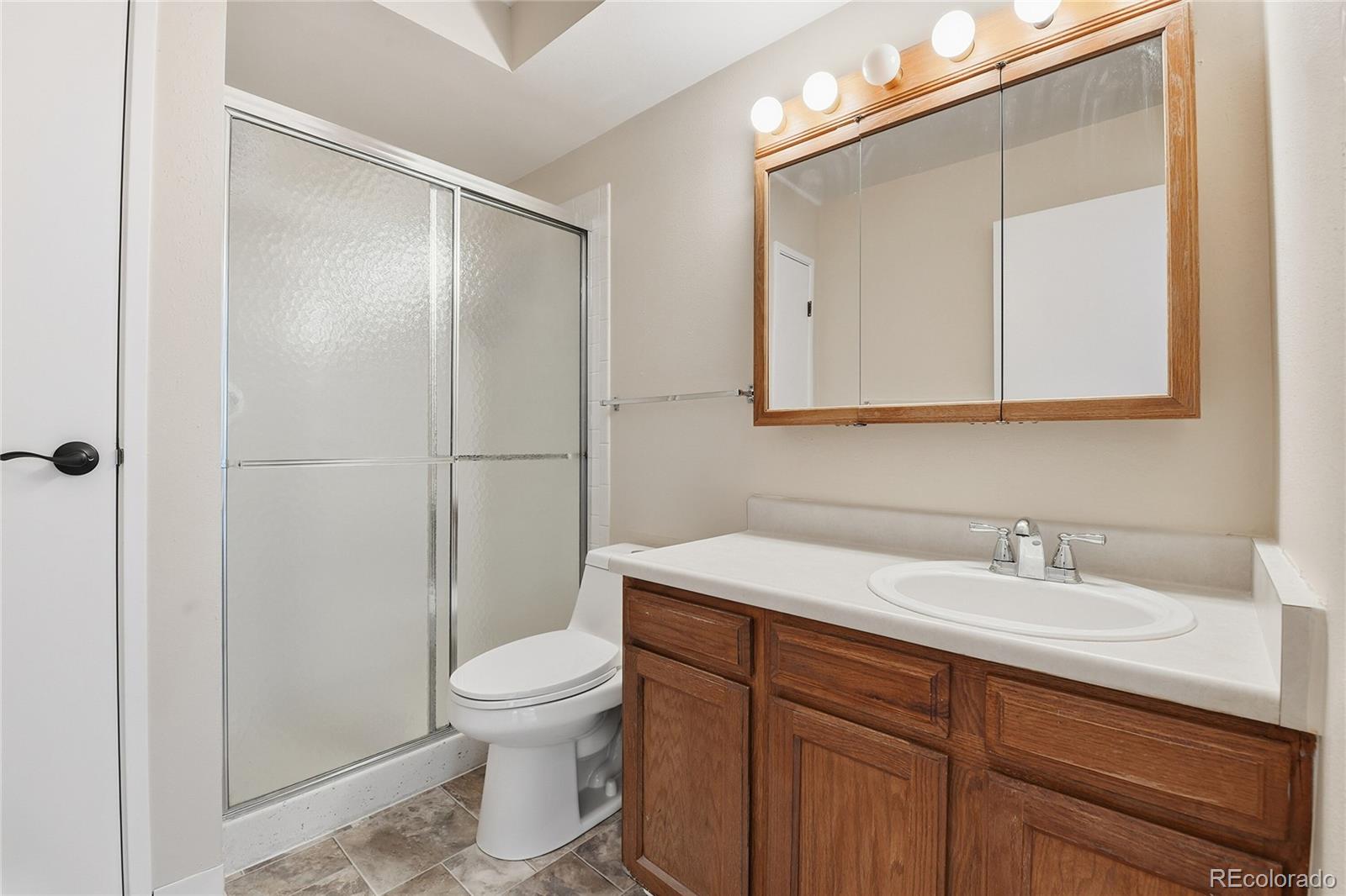 3022 South Wheeling Way, Unit 309 Aurora, CO 80014 - Photo 17 of 26 a bathroom with a sink toilet a mirror and shower