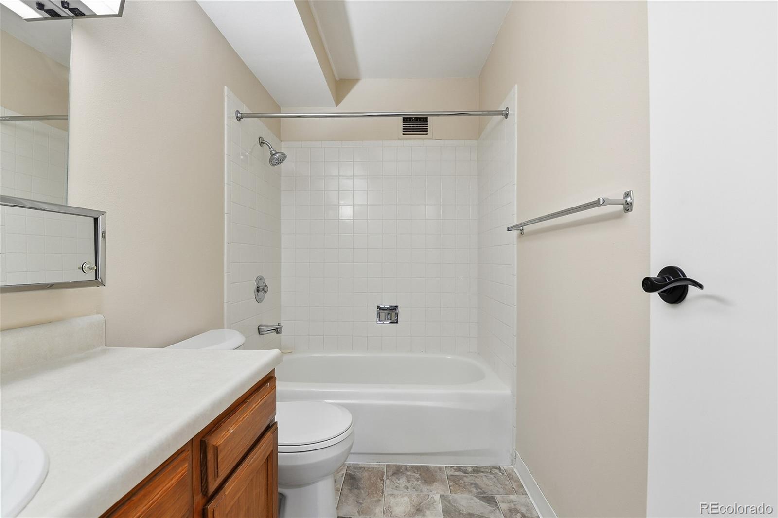 3022 South Wheeling Way, Unit 309 Aurora, CO 80014 - Photo 21 of 26 a bathroom with a granite countertop bathtub shower sink vanity and toilet
