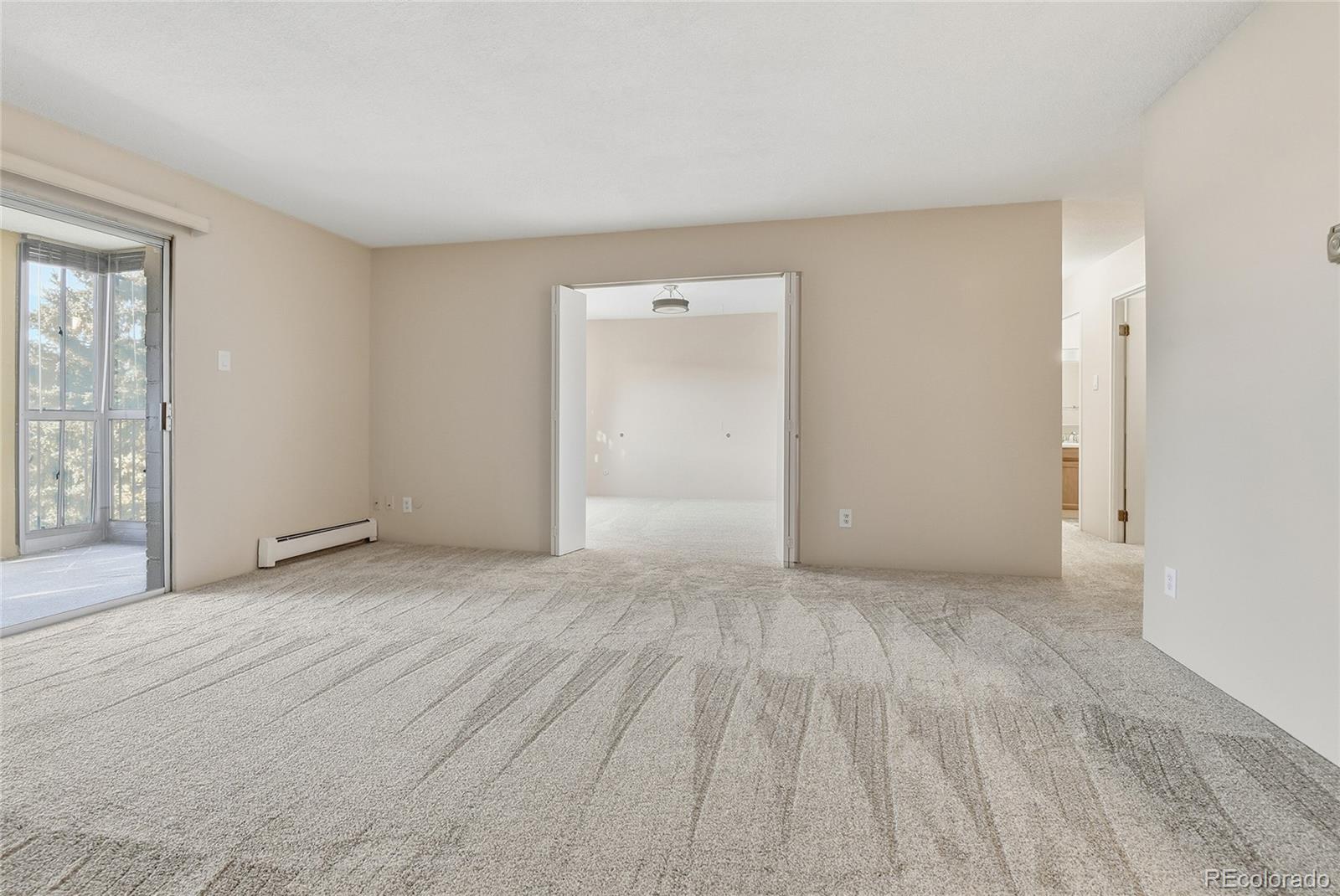 3022 South Wheeling Way, Unit 309 Aurora, CO 80014 - Photo 8 of 26 a view of an empty room with wooden floor and a window