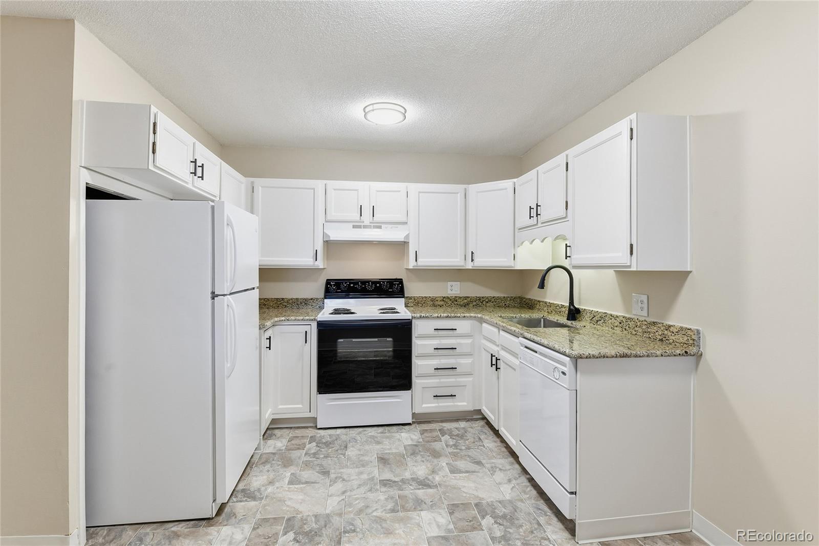 3022 South Wheeling Way, Unit 309 Aurora, CO 80014 - Photo 9 of 26 a kitchen with stainless steel appliances granite countertop a refrigerator sink stove and white cabinets