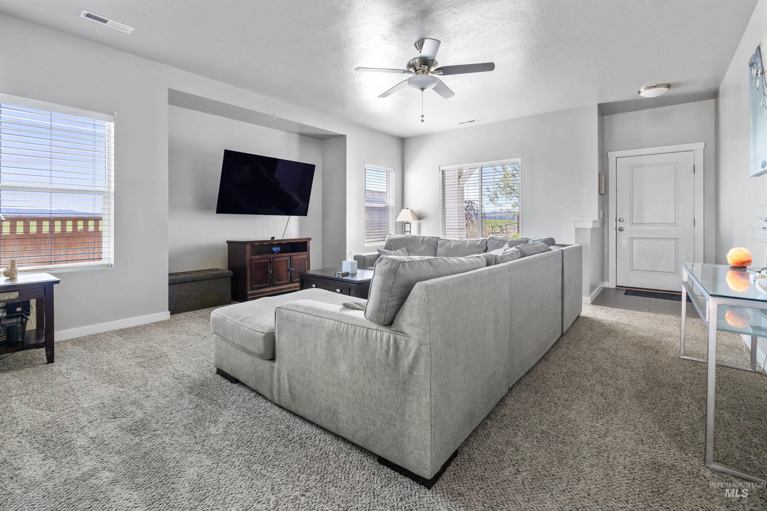 6988 West Spur Street Boise, ID 83709 - Photo 12 of 37 Carpeted living room with ceiling fan and baseboards