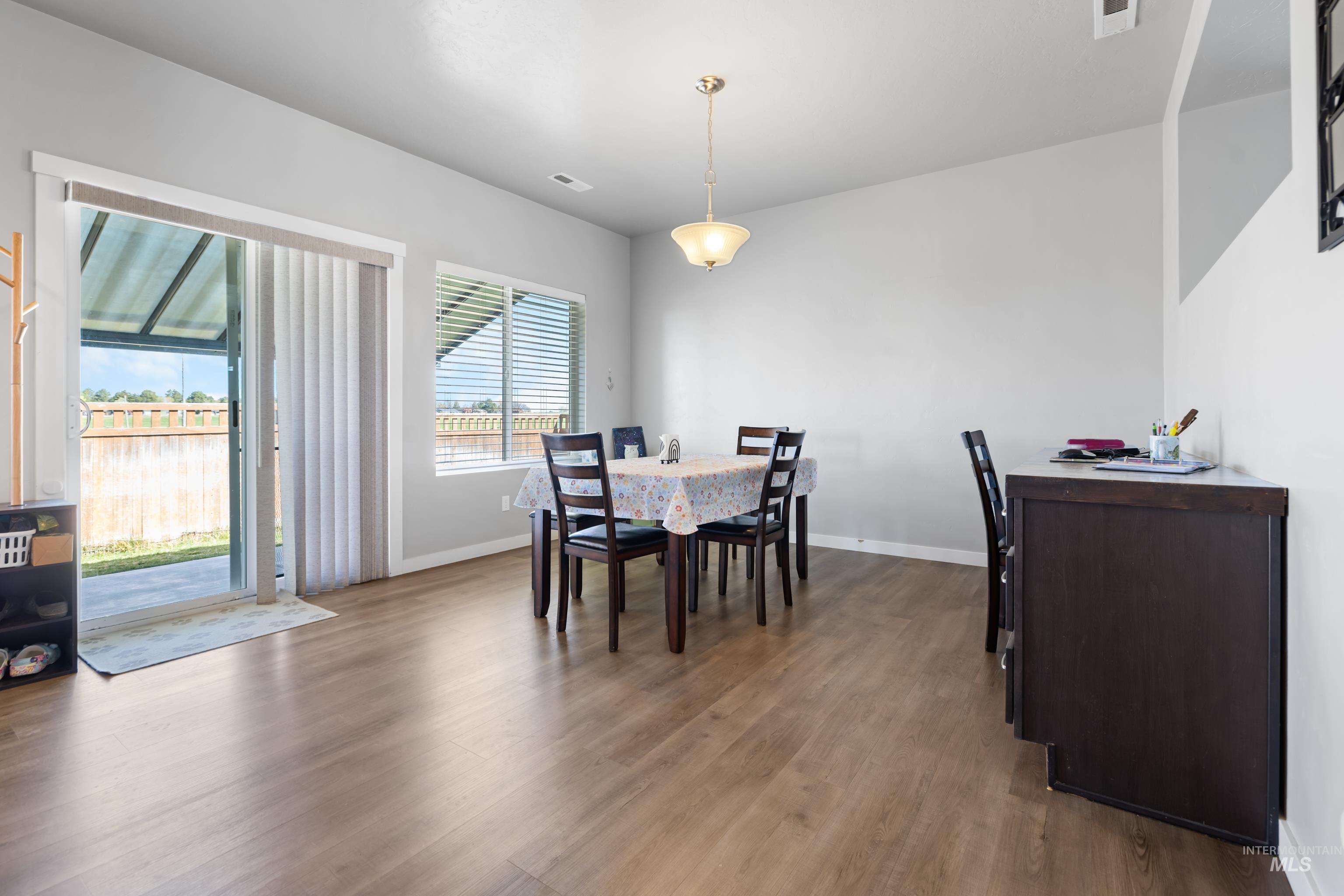 6988 West Spur Street Boise, ID 83709 - Photo 13 of 37 Dining room featuring dark wood-type flooring and baseboards