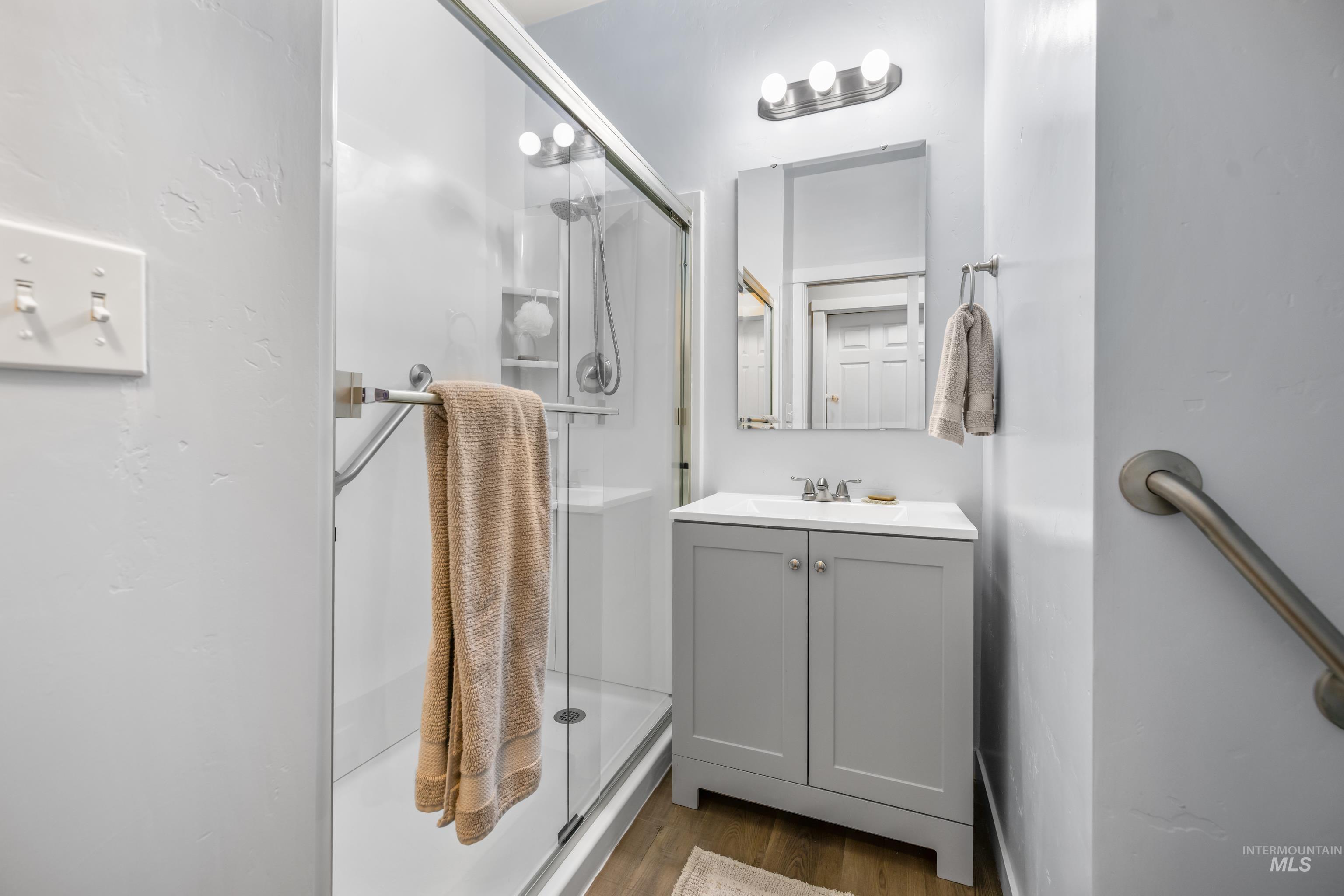 6988 West Spur Street Boise, ID 83709 - Photo 15 of 37 Full bathroom featuring vanity, dark wood finished floors, and a shower stall