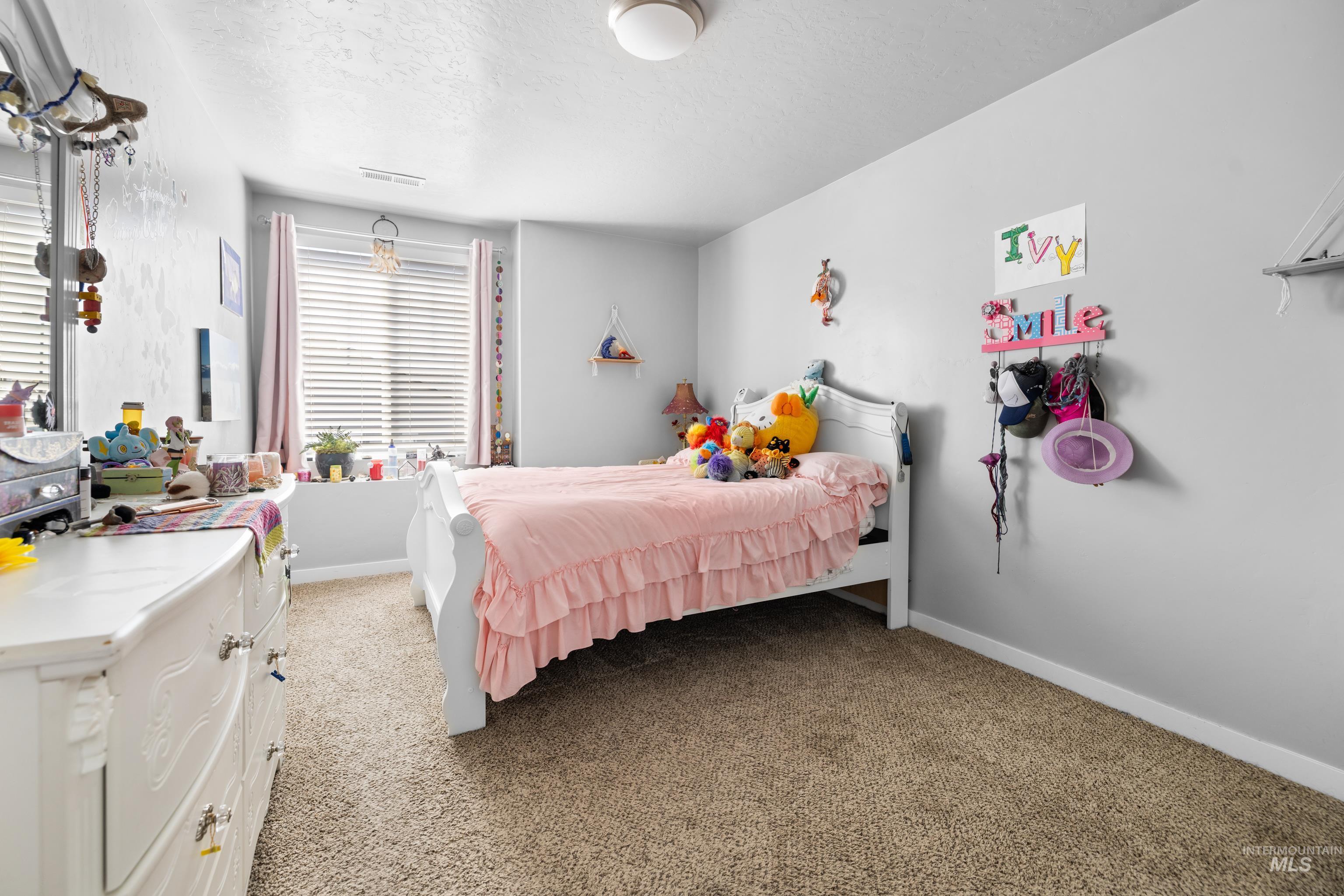 6988 West Spur Street Boise, ID 83709 - Photo 21 of 37 Carpeted bedroom featuring baseboards and a textured ceiling
