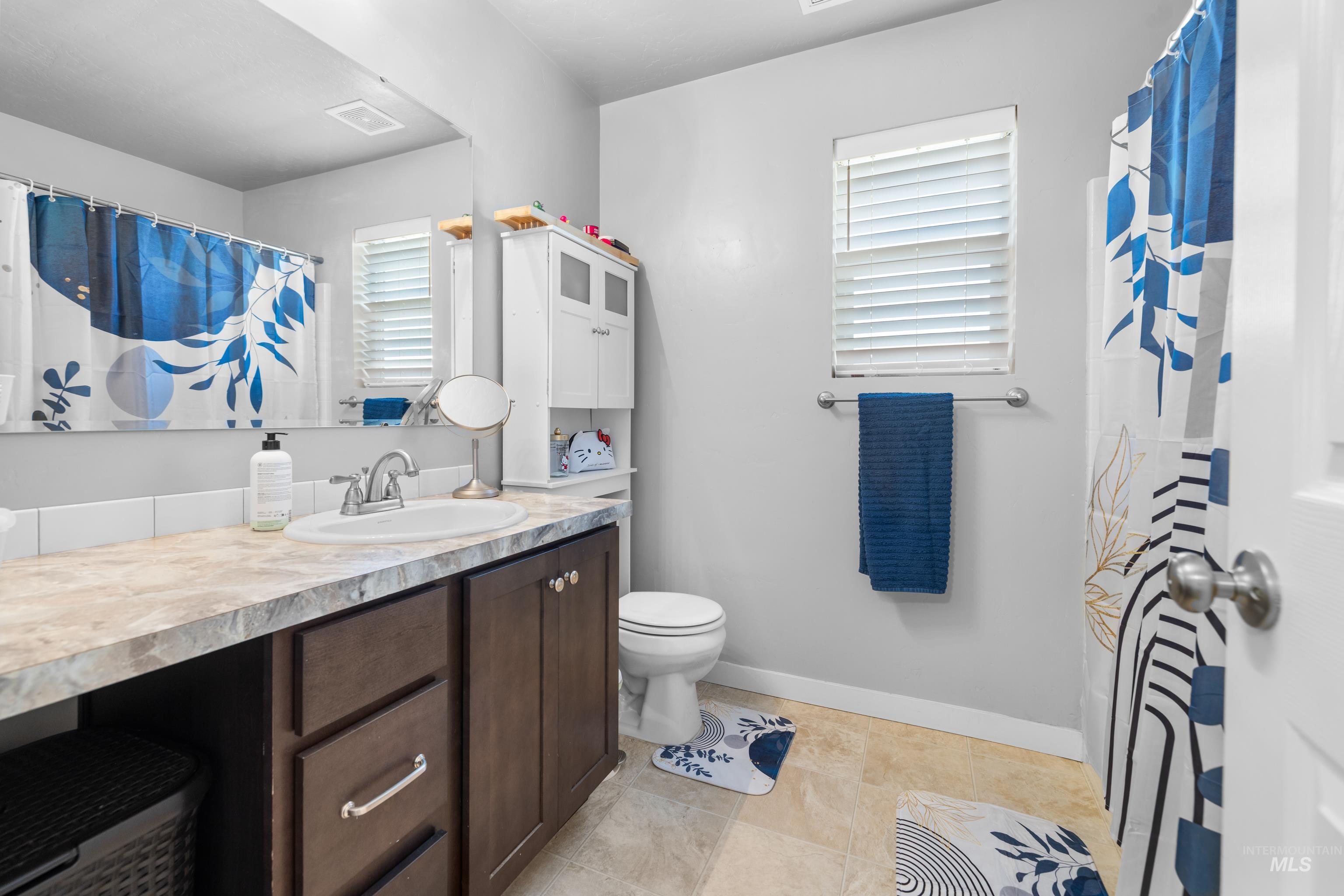 6988 West Spur Street Boise, ID 83709 - Photo 23 of 37 Full bath with vanity, a shower with curtain, and light tile patterned floors