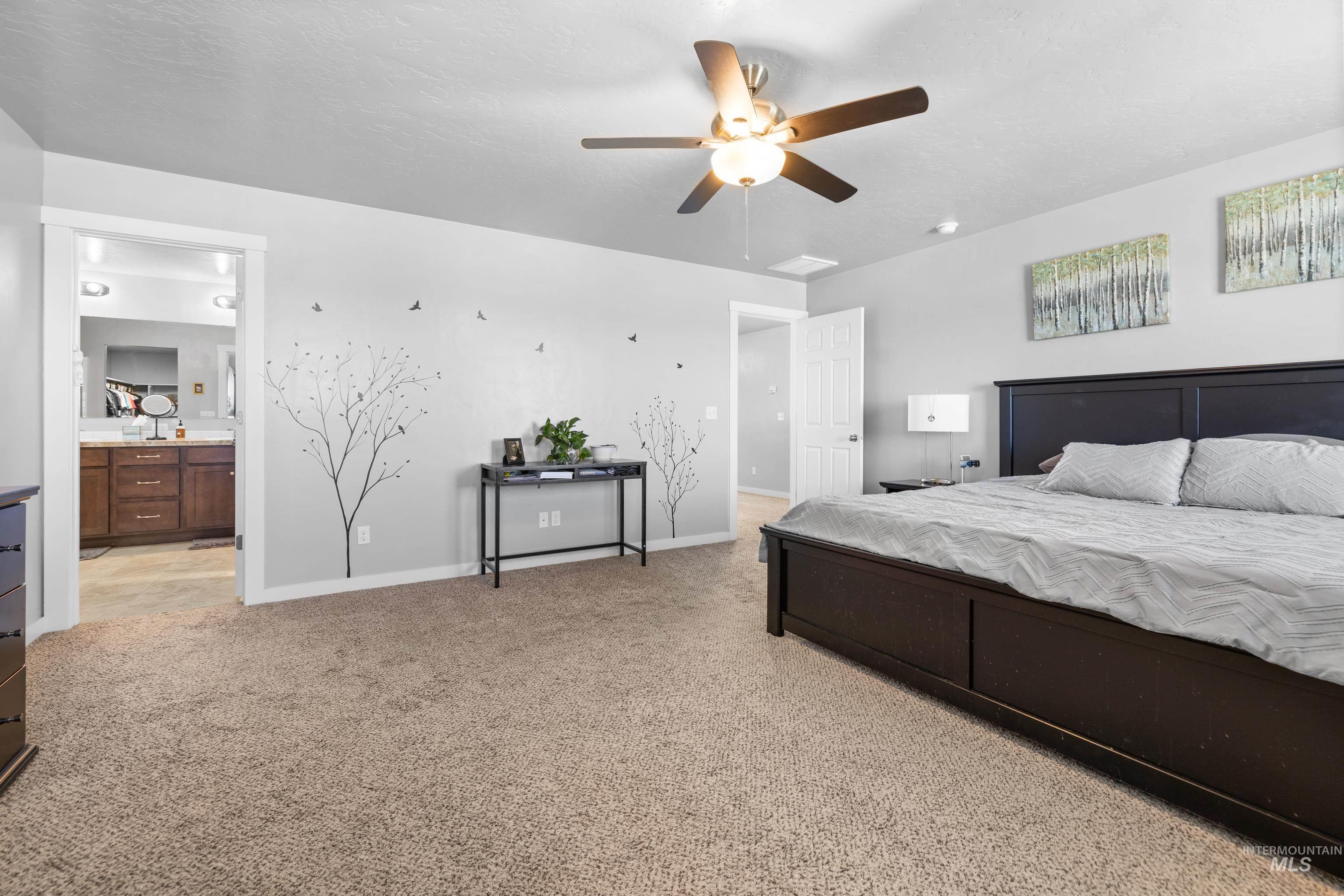 6988 West Spur Street Boise, ID 83709 - Photo 28 of 37 Bedroom featuring connected bathroom, light carpet, and a ceiling fan