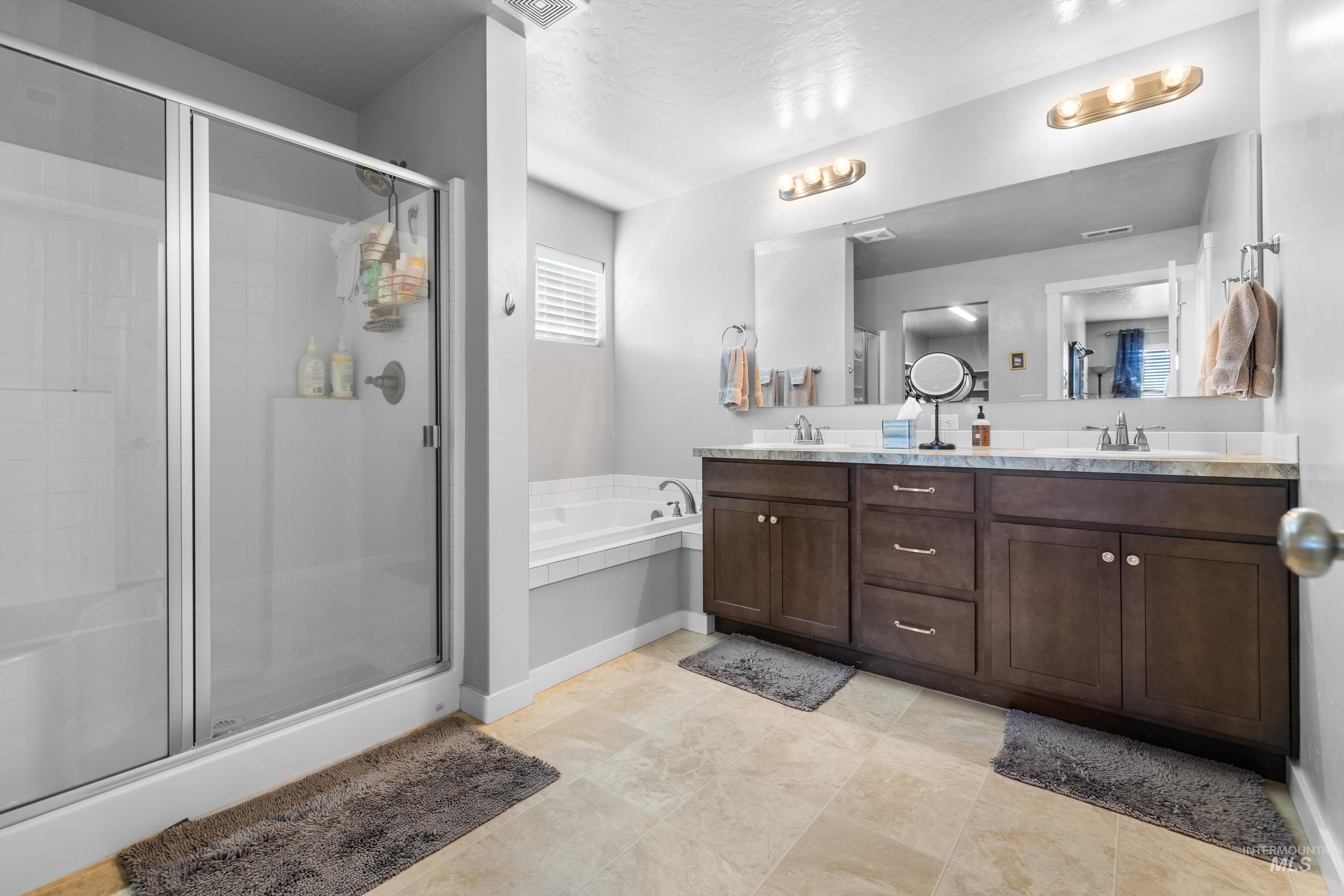 6988 West Spur Street Boise, ID 83709 - Photo 29 of 37 Bathroom with double vanity, a stall shower, and a bath
