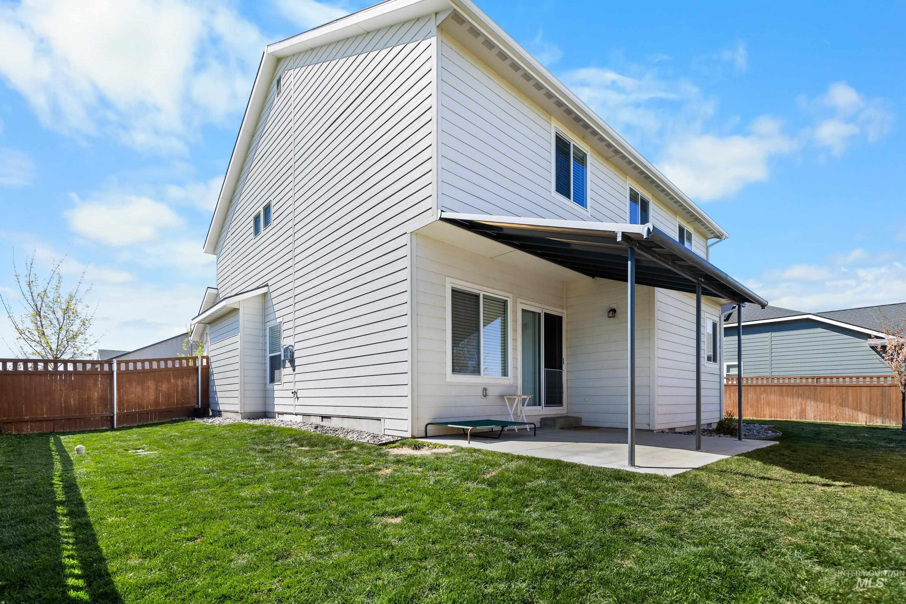 6988 West Spur Street Boise, ID 83709 - Photo 4 of 37 Side view of house with a fenced backyard and a patio