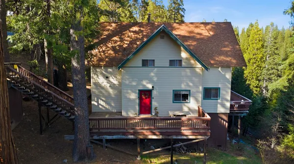 a view of a house with a yard and tree s