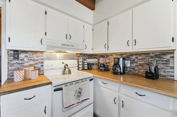 a kitchen with a stove and a wooden cabinets